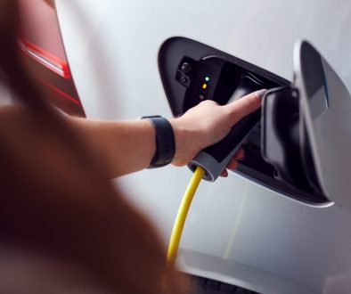 Close Up Of Hand Attaching Power Cable To Environmentally Friendly Zero Emission Electric Car